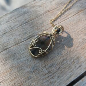 Handgemaakte wire wrap van Chiastoliet met vergulde koperdraad